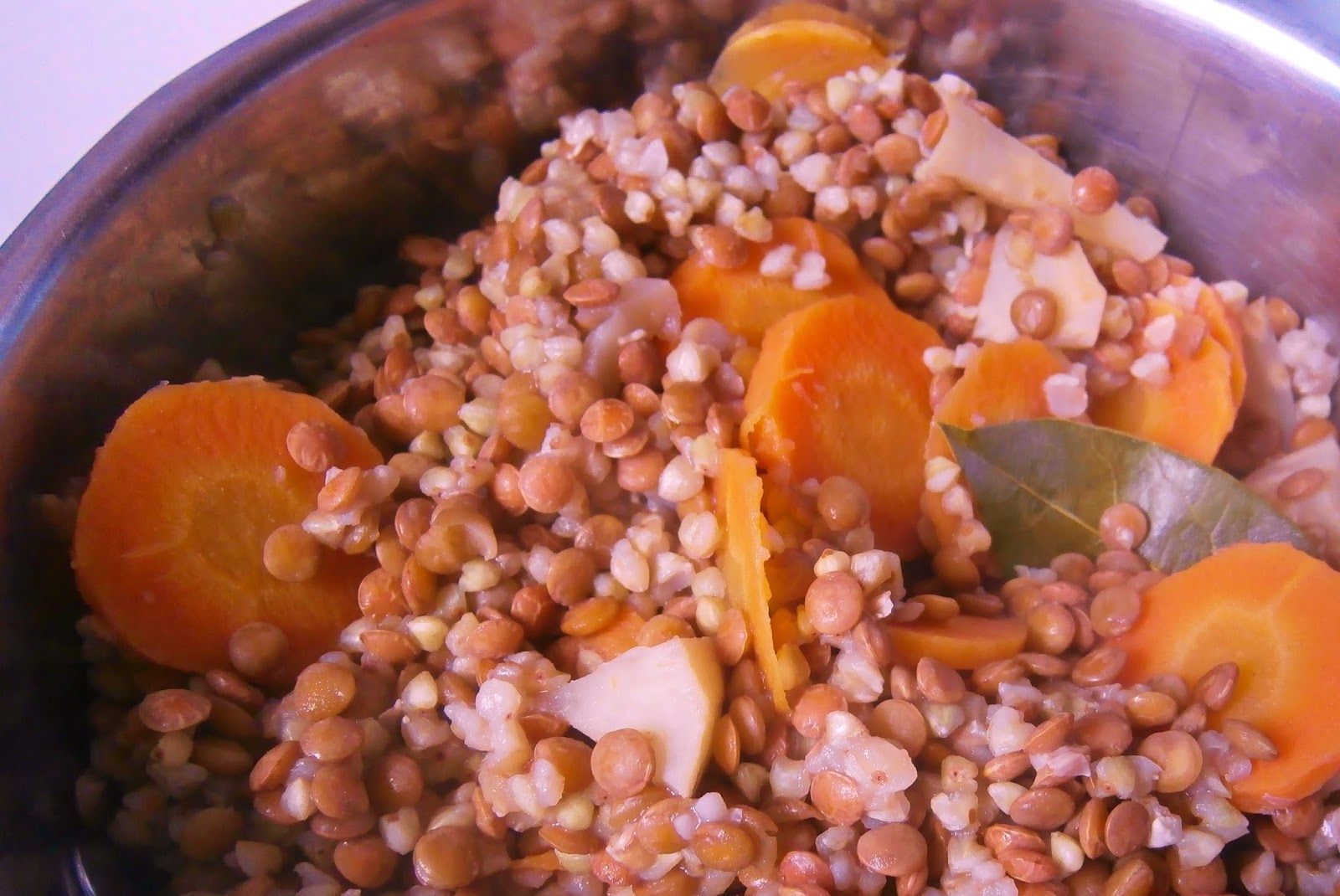 Marmite de grains cuits, lentilles et carottes tranchées, tons chauds orangés et bruns, plat mijoté réconfortant
